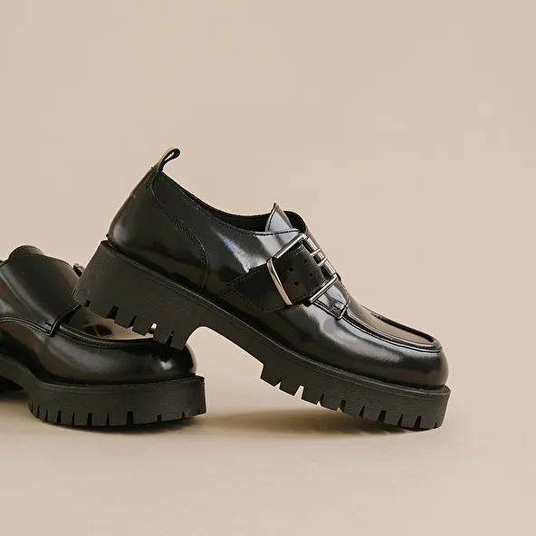 Derbies with flat heels, buckles and visible seams in black shiny leather