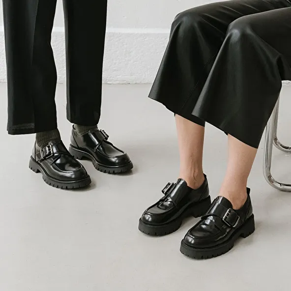 Derbies with flat heels, buckles and visible seams in black shiny leather