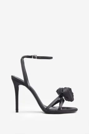 Strappy black satin heeled sandals with floral embellishments.